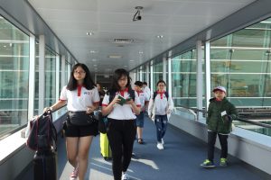 People walking on an air bridge to get on an airplane